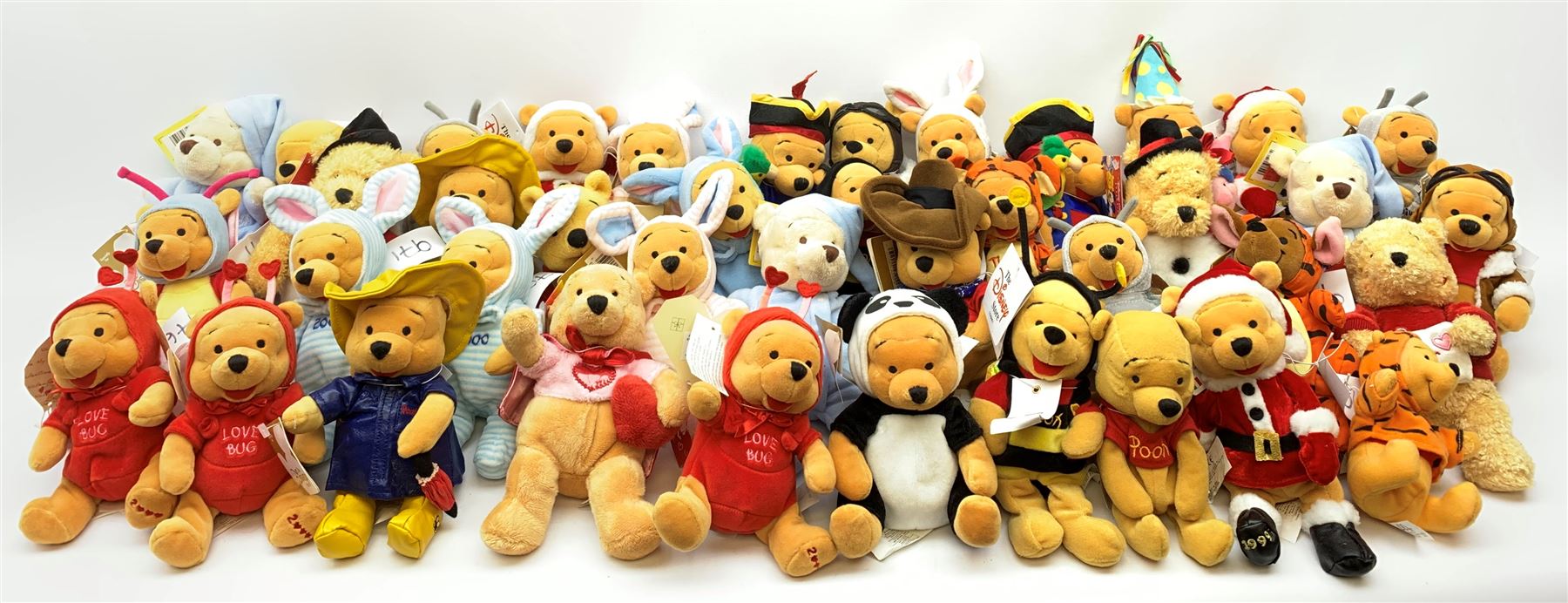 Forty Walt Disney character Pooh bears including Santa, Easter 2000, Raincoat, Snowman, Pirate, Millenium Bug, Bumble Bee, Aviator, Lovebug etc.(some duplicates)