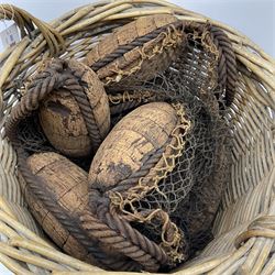 Herring net with six cork floats contained in a large two-handled wicker basket H45cm