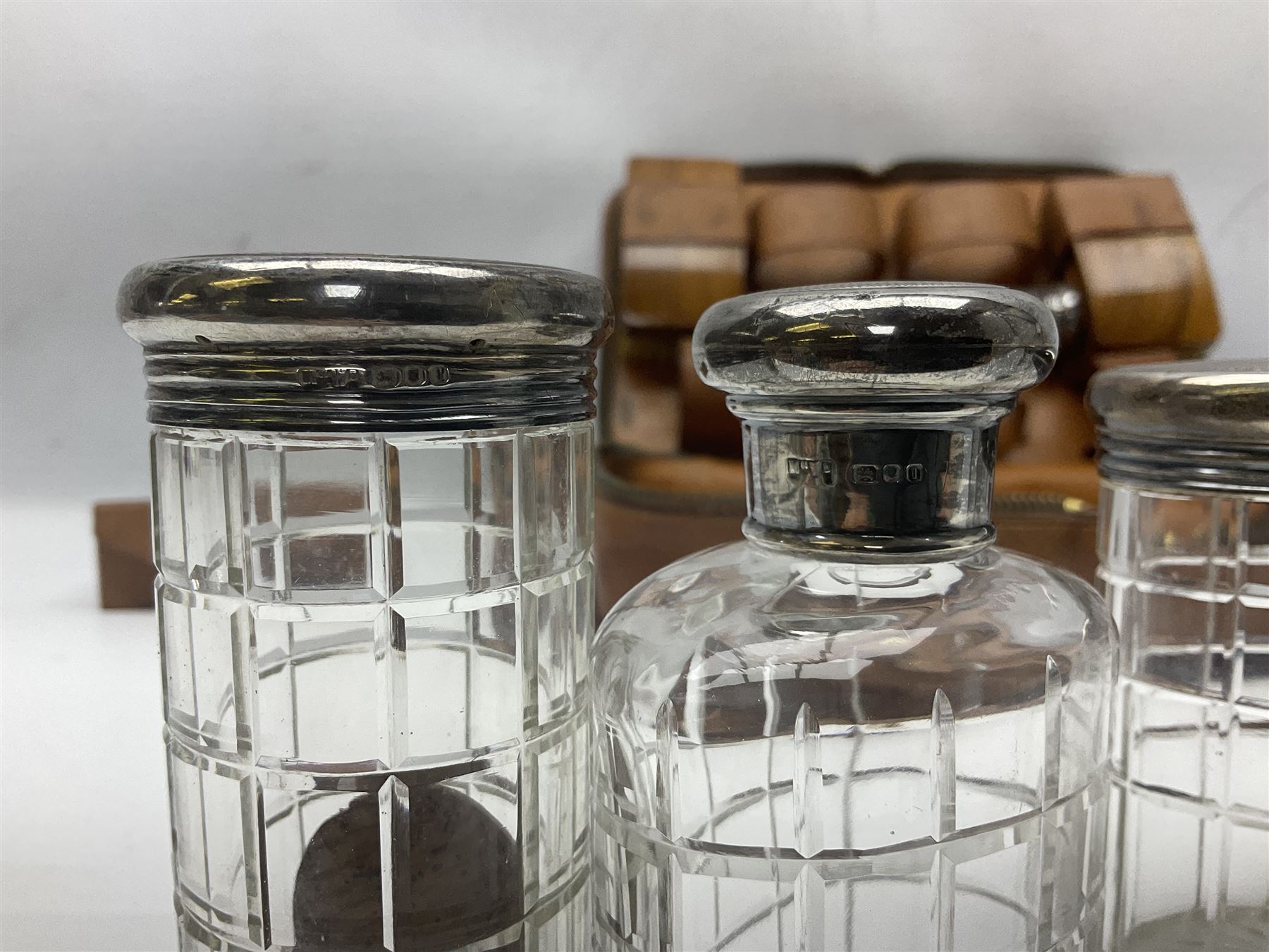 Mappin & Webb leather cased campaign gentleman's vanity set, the tan leather case opening to reveal fitted interior with five engine turned silver capped glass vanity bottles, hallmarked Mappin & Webb, London 1944, brushes, mirror etc, monogram DPK to the top of the case