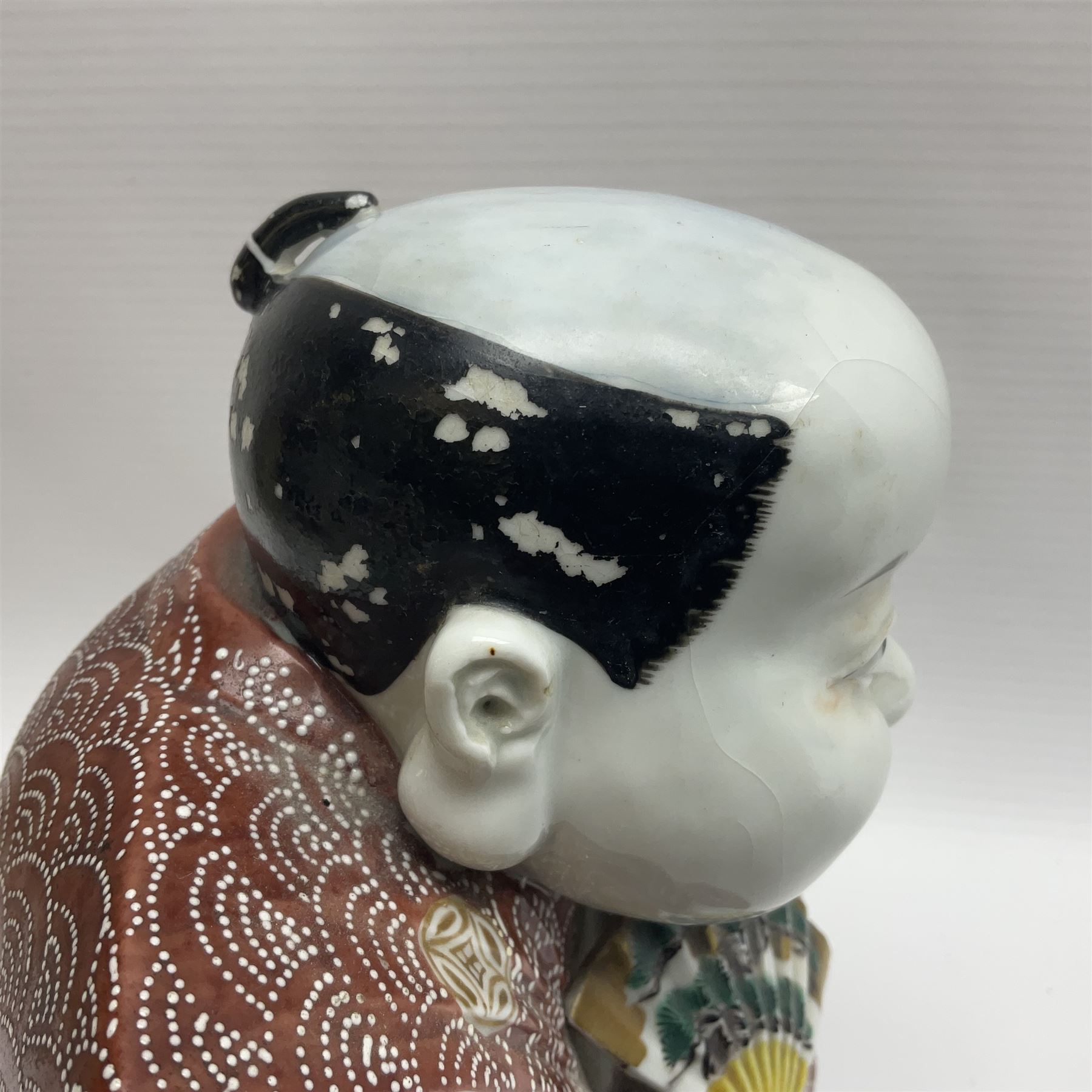 Japanese Fukusuke good fortune figure, modelled as a kneeling male figure holding a fan, dressed in traditional Samurai robes, H15.5cm