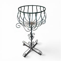 Matched pair of antique metal plant stands, each with circular strapwork basket tops, the scrollwork supports raised on an X-form base, in green painted finish with rustic patina