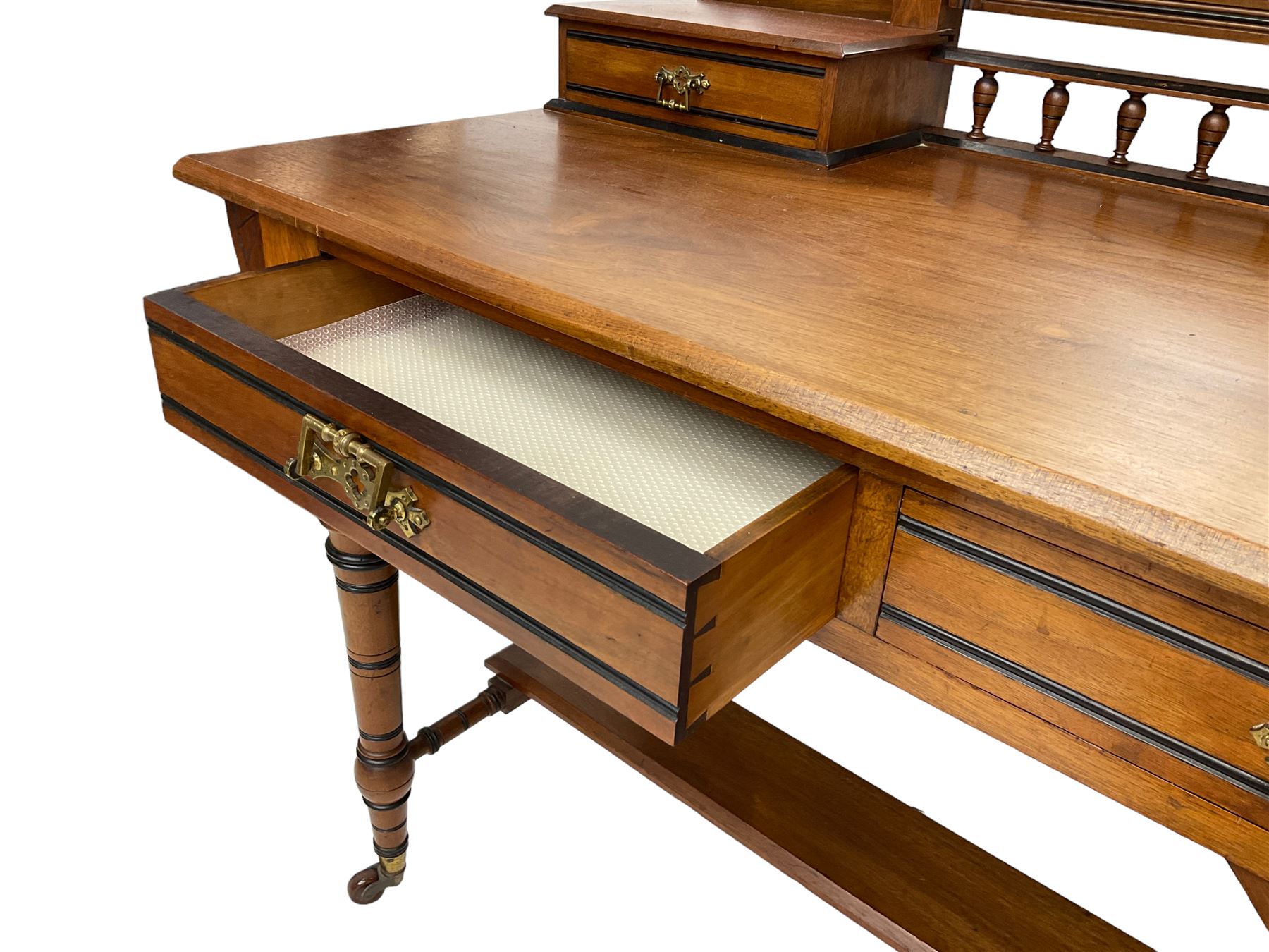 Late Victorian Aesthetic Movement walnut and inlaid ebony dressing table, swing mirror back with shell carving and spindle support rail, fitted with two trinket drawers and single frieze drawer, raised on ring turned supports with castors