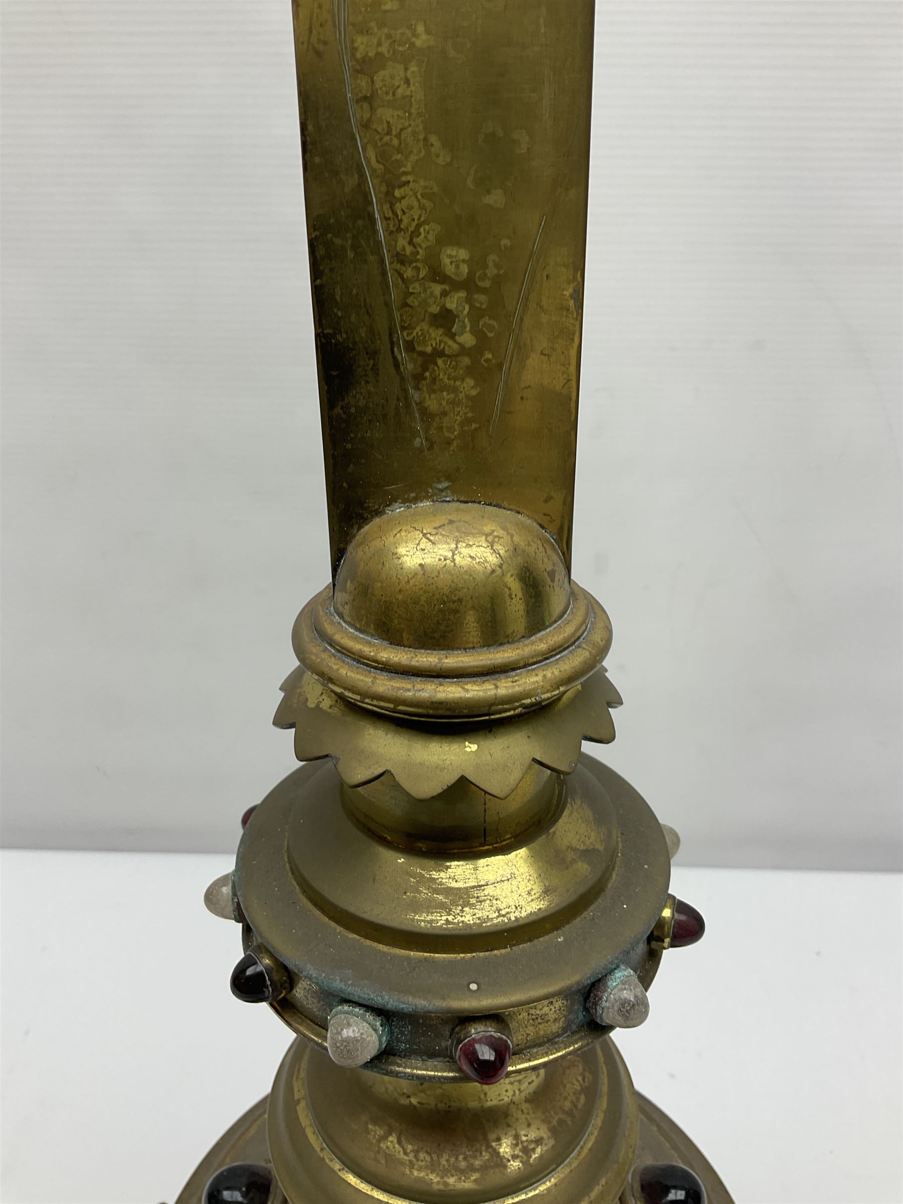 Brass alter cross, decorated with glass cabochons, upon a acicular stepped base and three claw feet, H73cm 