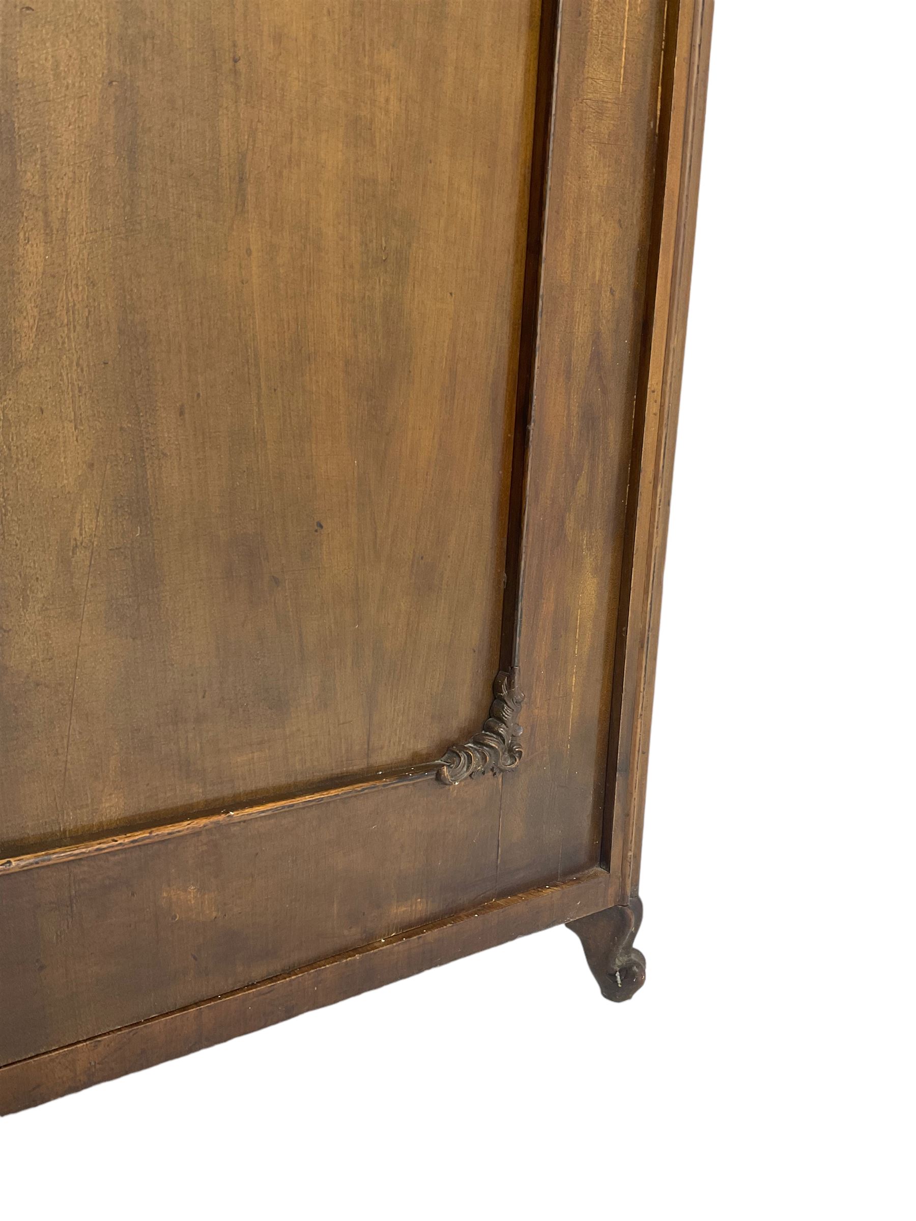 Early 20th century Italian walnut armoire wardrobe, the pierced and scrolling pediment carved with acanthus leaf detail, flanked by two scrolling cartouche with matching corbels below, the two panelled doors with applied carved rinceaux slips, with a central spiral turned upright, enclosing single shelf and hooks, raised on scroll feet