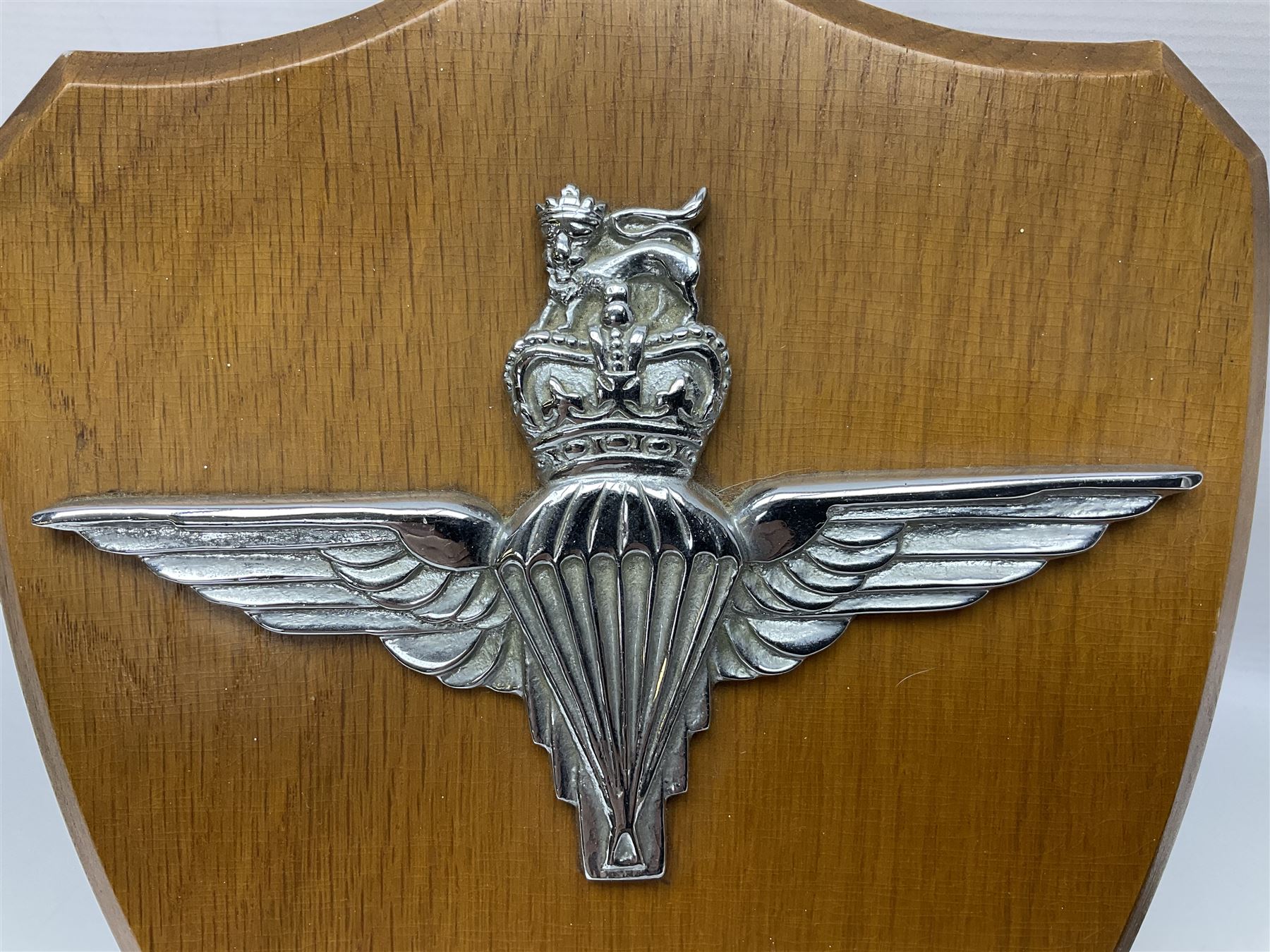 Parachute regiment - chrome crest on oak easel shield; three cloth badges; small silver plated figure; and pin badge; together with 10cm diameter cannon ball etc