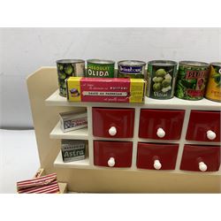 Late 1950s continental red and white painted wooden diorama of a grocery shop interior with fitted shelves and drawers and freestanding 'glazed' counter, fully stocked with miniature tin cans and packets of food L42cm H23cm D22cm