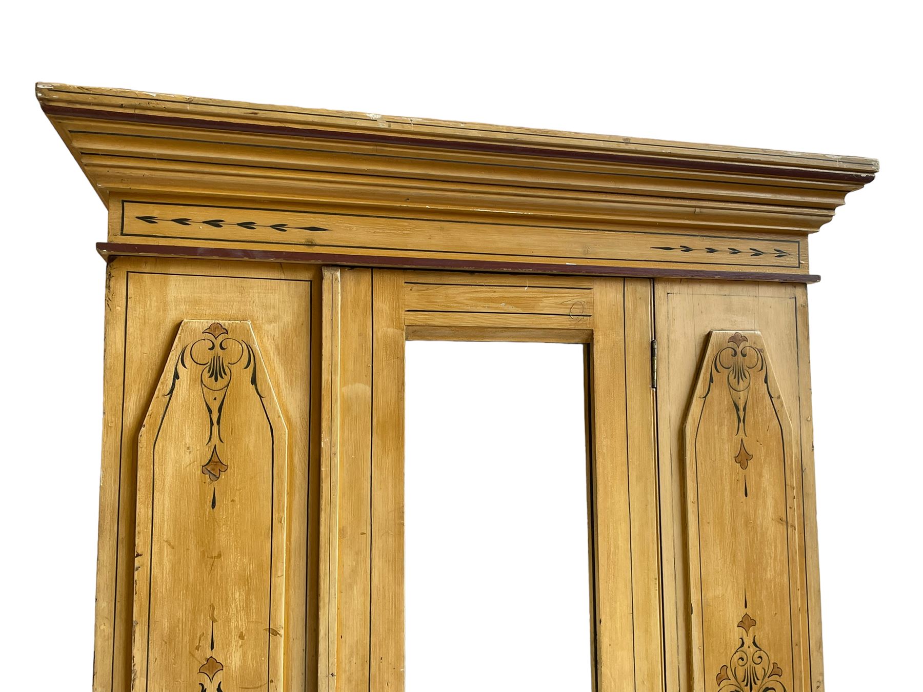 19th century painted pine wardrobe, the projecting cornice over mirror glazed door, with painted decoration depicting scrolling foliate and urns, drawer to base on skirt
