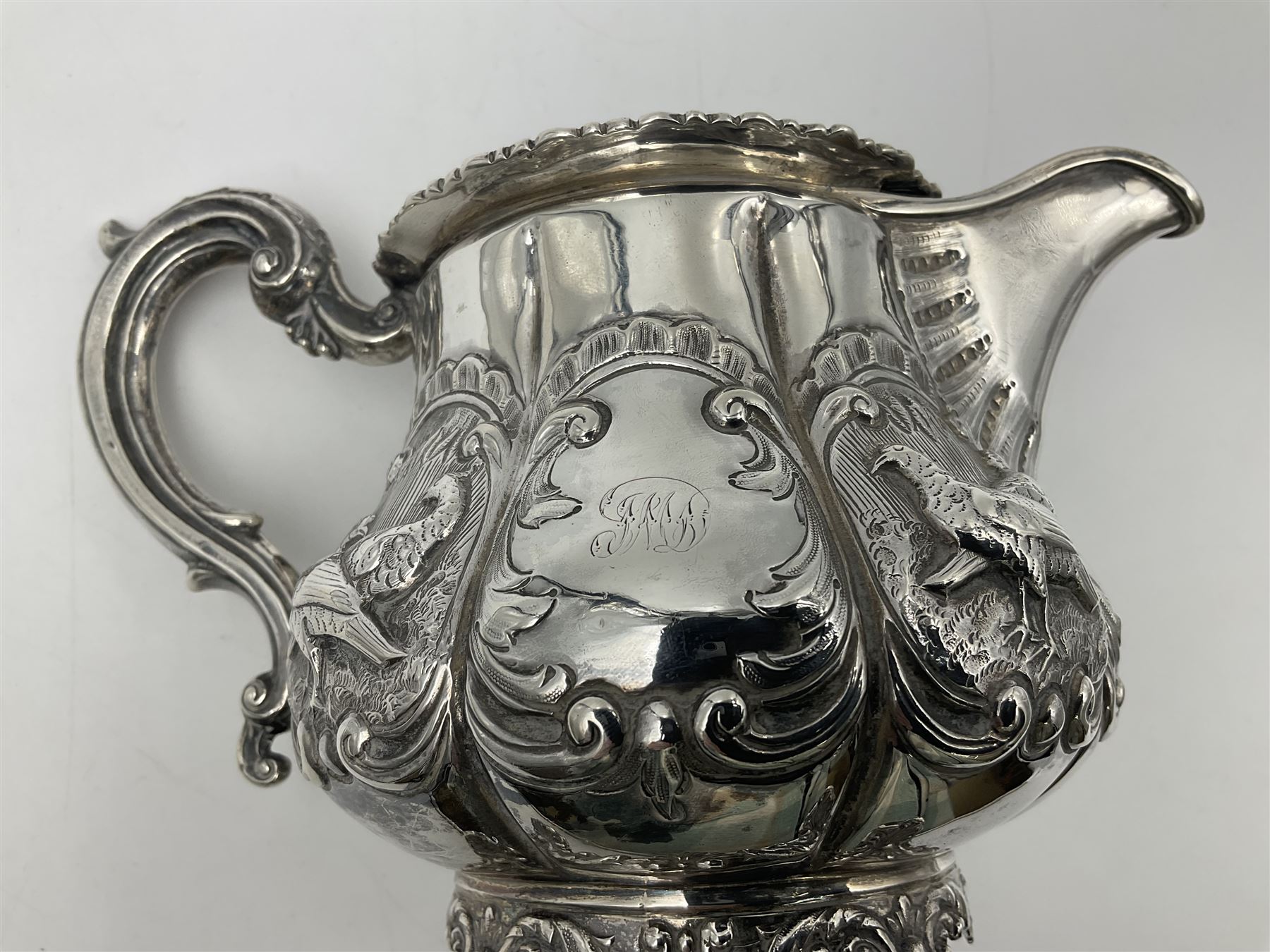 Victorian silver three piece tea service, comprising teapot, twin handled open sucrier, and milk jug, each of bellied form with acanthus capped scroll handles, the sides embossed with alternating scroll edged vacant panels and panels containing a pair of birds, upon four palmette feet, the teapot with ivory insulators to handle, and bird finial to the hinged domed cover, hallmarked William Hunter & Son, London 1861, teapot H19cm, including handles sucrier H13.5cm, including handle milk jug H12cm

This item has been registered for sale under Section 10 of the APHA Ivory Act