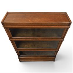 Globe Wernicke - early 20th century oak stacking bookcase, three tiers, lift up glazed doors raised on a plinth base