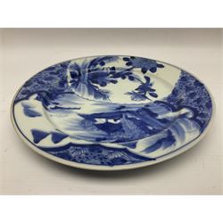 Japanese Meiji period Arita blue and white plate, of circular form, painted with riverside landscape and bird upon flowering branch, with character mark beneath, D24.5cm, together with two 18th century Chinese blue and white plates, each painted with floral design, each approximately D22.5cm