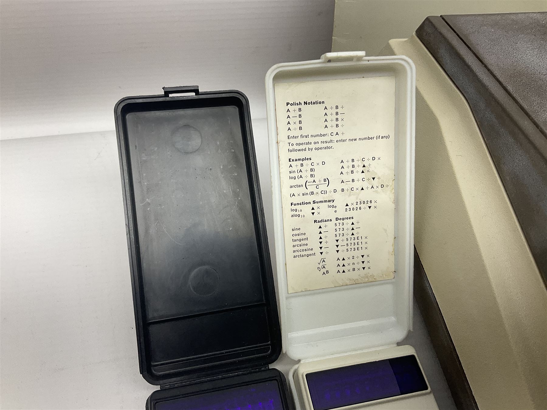 Four 1970s Sinclair electronic calculators - Cambridge in hard case with booklet; Scientific Programmable with Program Library and booklet; Scientific in hard case; and Oxford 300 in soft case with booklet; together with Texas PC-100 SR56 programmable slide-rule calculator on base station with readout, two booklets, keys and cover, serial no.9103093