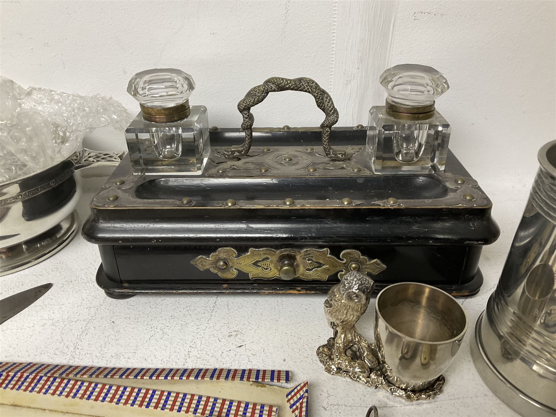 Victorian ebonised wooden desk stand, with brass mounts and two glass inkwells, together with two pewter tankards with Masonic engravings, two pewter quaiches, horn handled carving set, the fork with silver mounts and a collection of other metalware