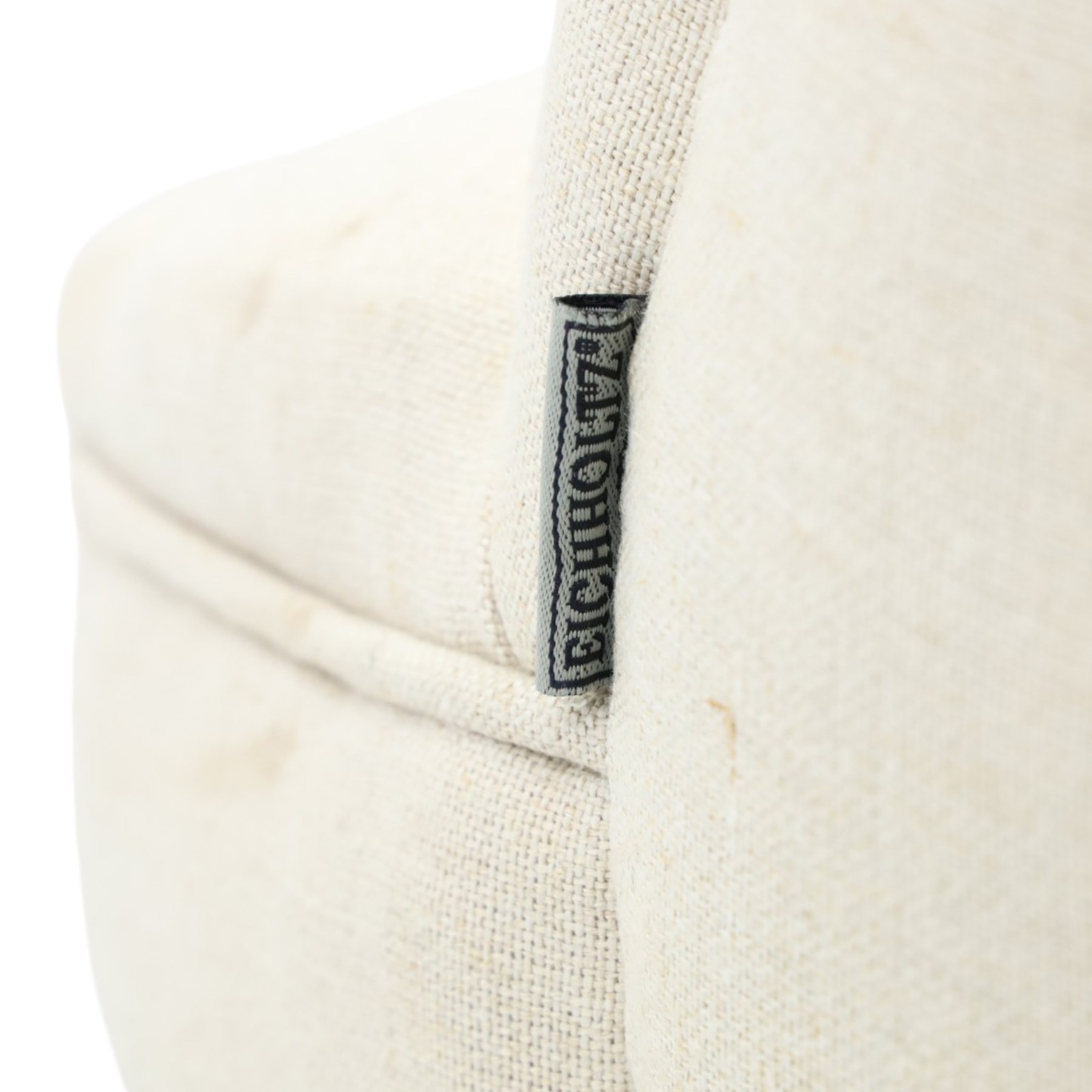 Victorian style upholstered tub chair, buttoned cream fabric back and seat with rolled sides, on ebonised turned front supports with brass castors and splayed rear supports