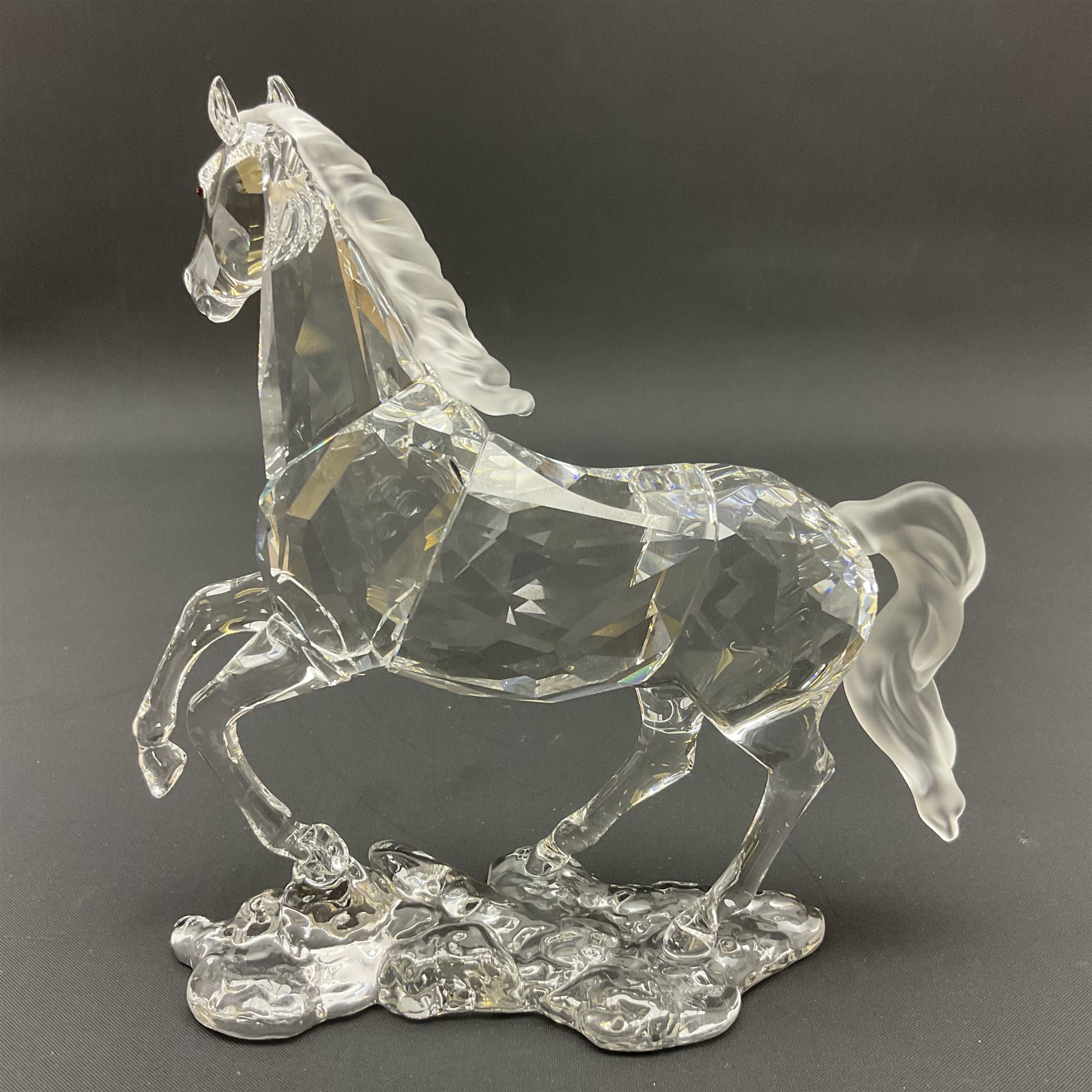 Five Swarovski Crystal horses, comprising stallion, rearing horse, pair of horses playing and Arabian stallion, each with frosted manes and tails, together with a small Swarovski Crystal galloping horse, the mane, tail and base with smoky tint
