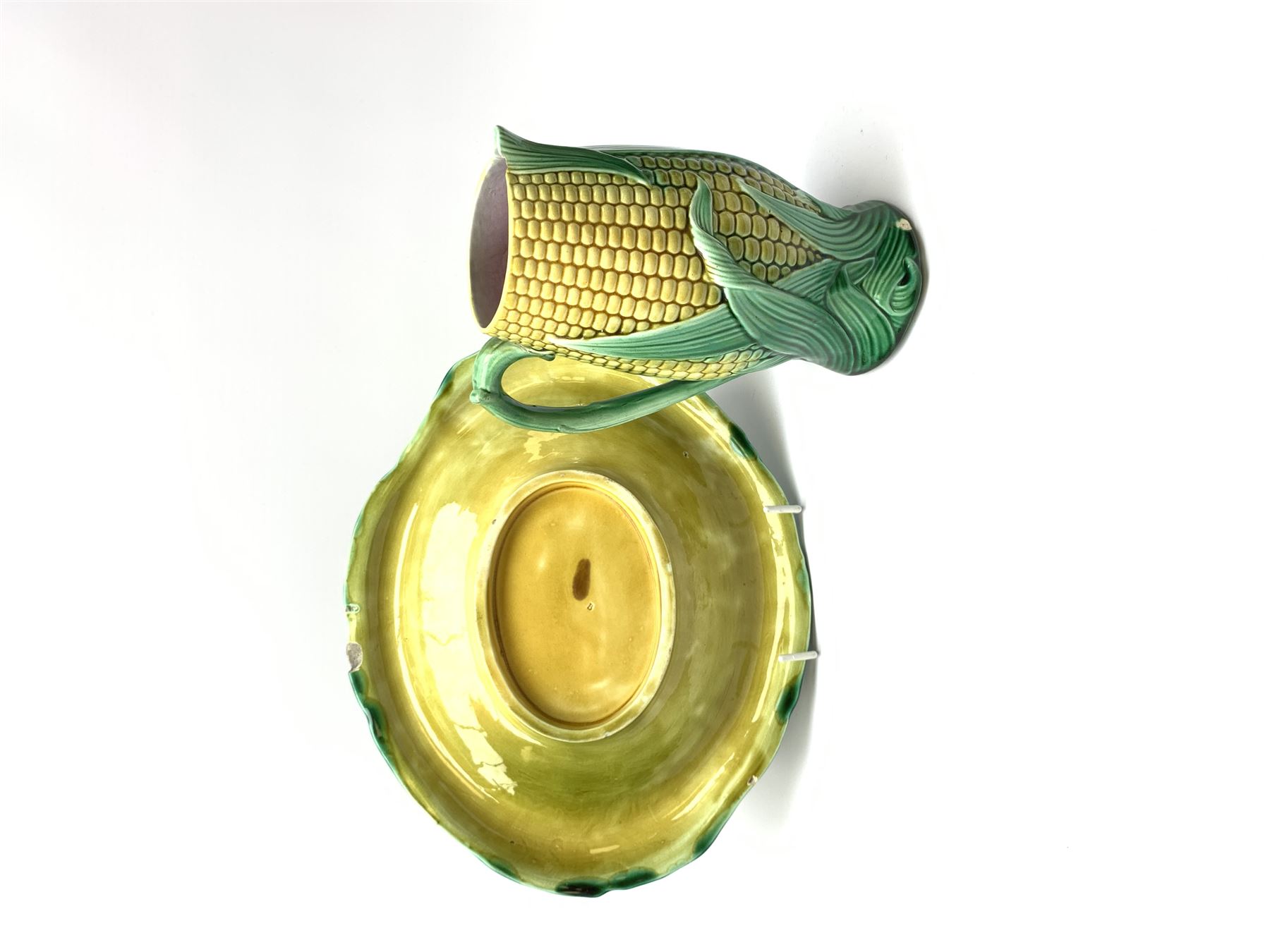 A Victorian majolica bread plate depicting corn within a woven basket, L33cm, together with a Victorian majolica jug modelled in the form of a corn cob, with registration mark beneath, H22cm. 