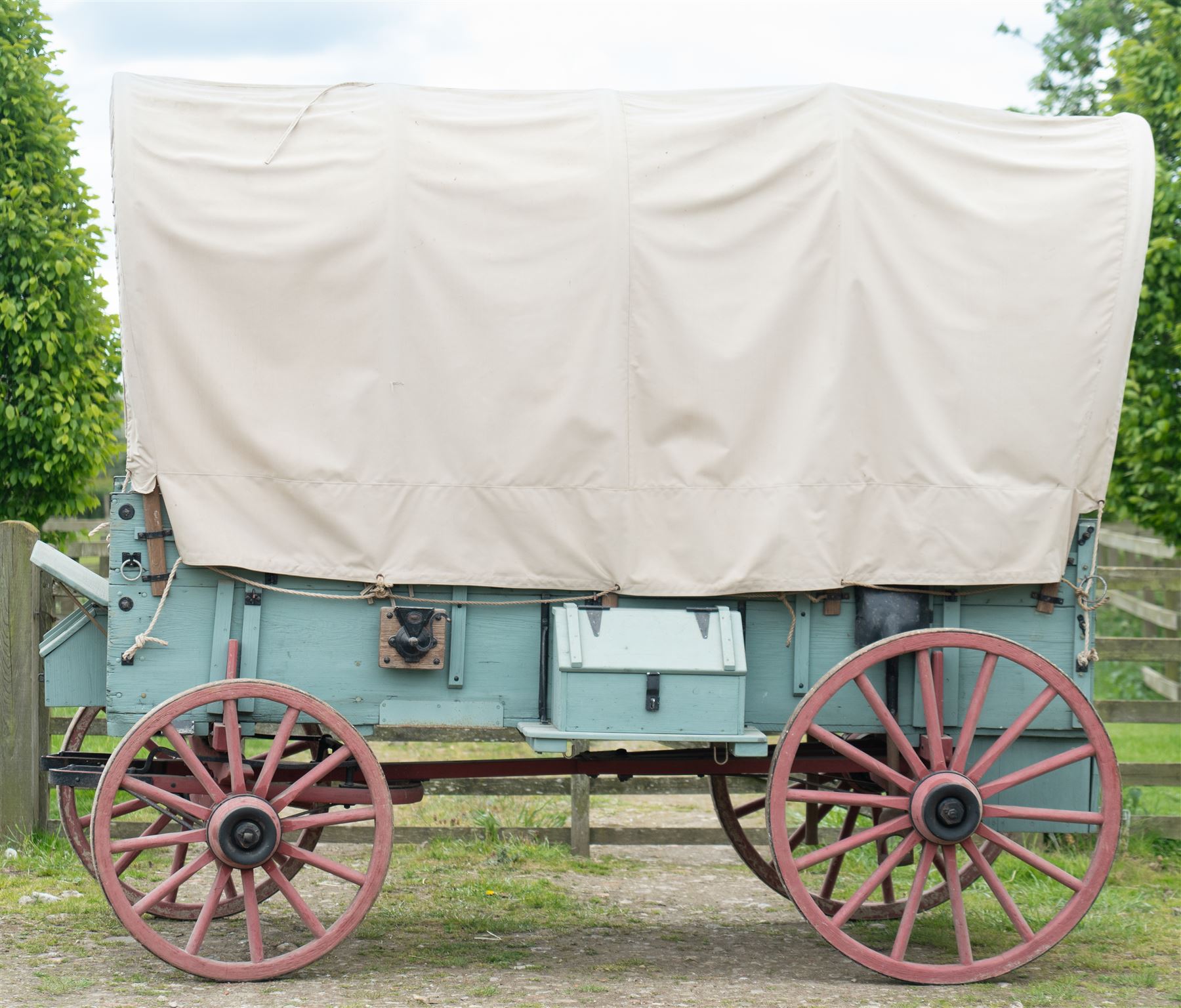 Western Covered Chuck Wagon

A large four wheeled covered wagon of timber construction, painted pale green with red painted wooden spoked wheels and a cream canvas tilt over an arched frame. The wagon has a traditional box body with covered rear compartment, front driving position, underbody turntable steering and iron fittings throughout. Fitted with external equipment details including a side mounted barrel, lidded storage chest, rope tie downs, horseshoe fittings and rear storage box.

Features

• Pale green painted timber body
• Cream canvas tilt over arched frame
• Covered rear compartment
• Front driving position
• Side mounted barrel
• External lidded storage chest
• Rear storage box
• Wooden spoked wheels
• Iron tyres
• Underbody turntable steering
• Rope tie downs
• Horseshoe fittings
• Iron hardware and brackets
• Brass restoration plaque to rear

Dimensions:
Overall length: 335 cm
Width: 170 cm
Height: 275 cm

Wheel Diameters:
Front wheels: 92 cm
Rear wheels: 112 cm

Seating:
Driver: 1
Passenger: Rear covered compartment