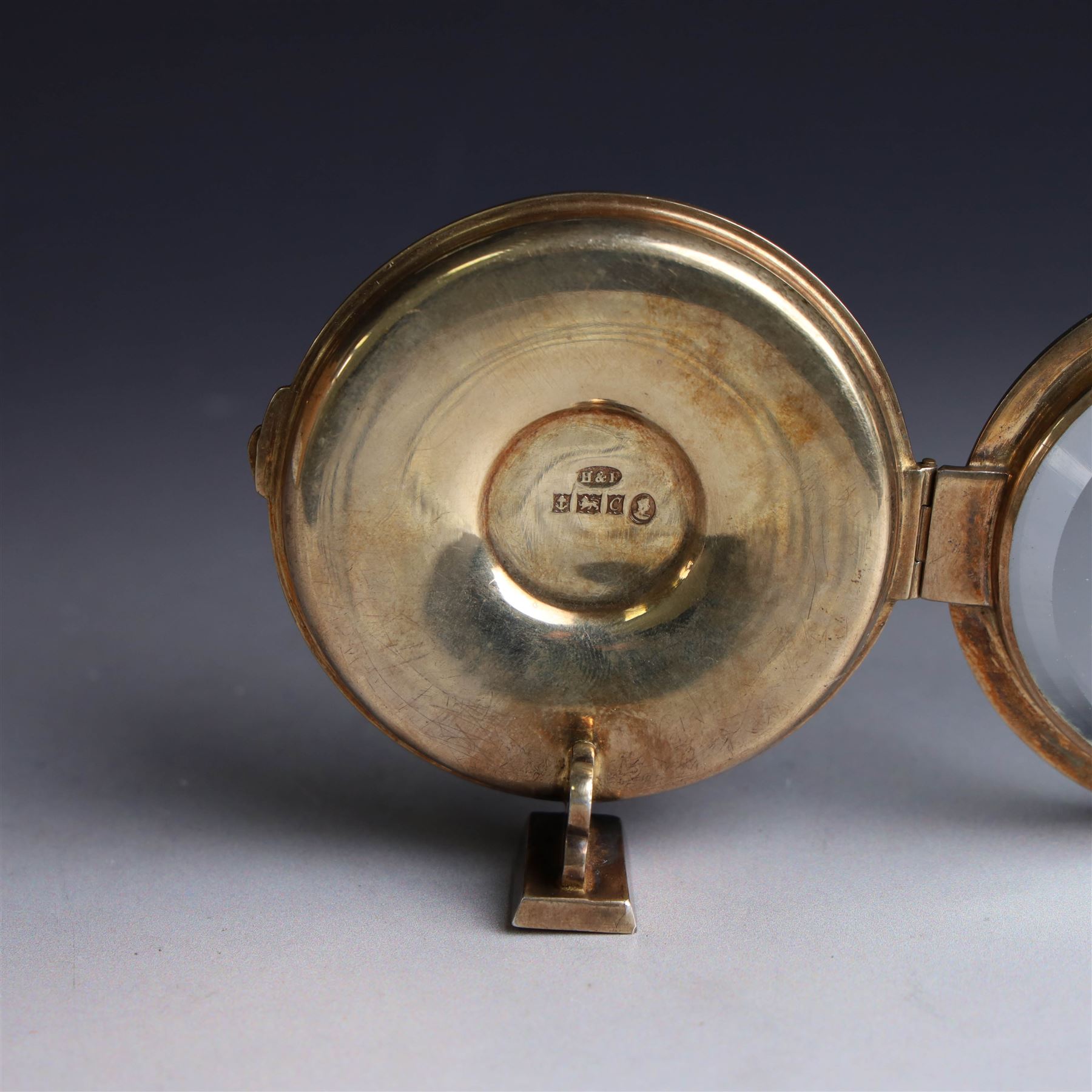 Late 20th century silver-gilt lunette, of circular form with bevelled glass centre, hallmarked Hayes & Finch Ltd, Birmingham 1977, H7.5cm