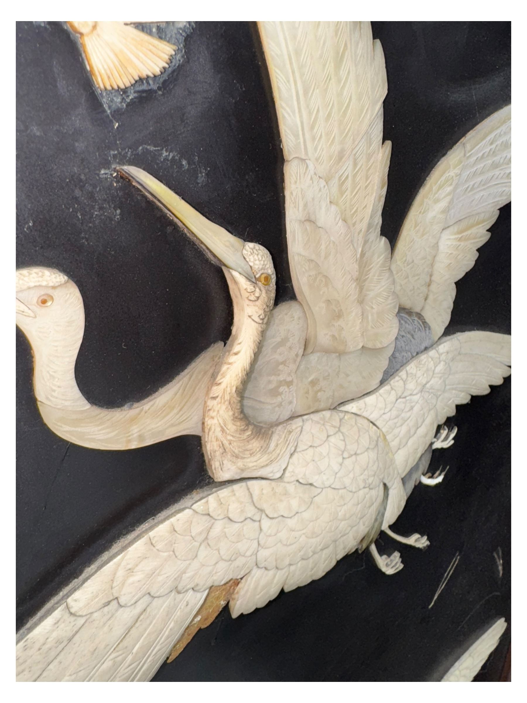 Meiji period (1868–1912), Shibayama lacquer carved hardwood two-fold screen inlaid with mother-of-pearl, bone, and ivory, decorated on one side in high relief and inlaid in a  Shibayama manner with oriental storks flying below flowering branches,  the reverse lacquer panels depicting flowering cherry trees. This item has been registered for sale under section 10 of the APHA Ivory Act.