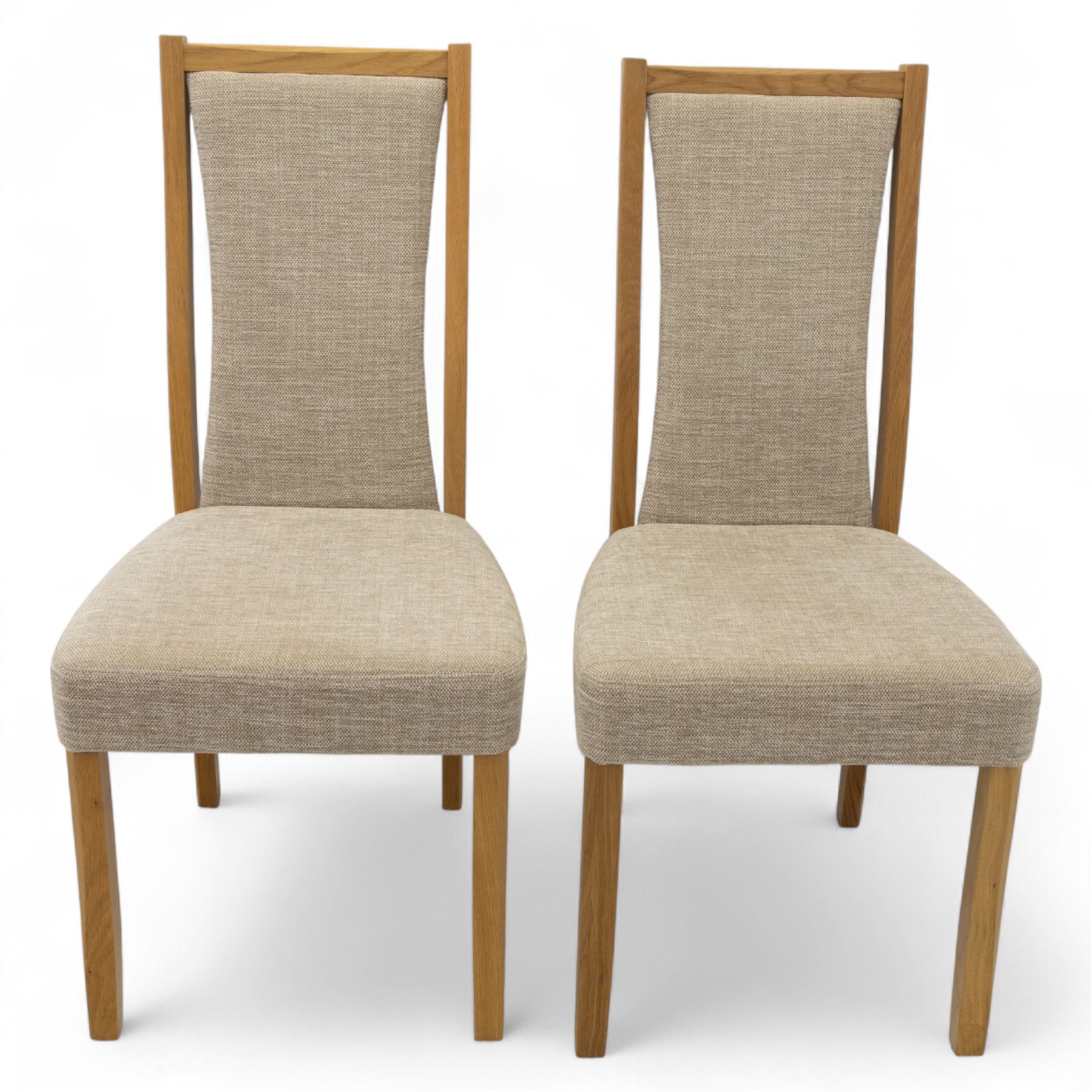 Ercol - light oak ‘Artisan’ rectangular dining table with chamfered top extending fold over top and tapered legs, together with two matching high back dining chairs upholstered in textured beige fabric (Chairs H 98cm, W 47cm, D 52cm)