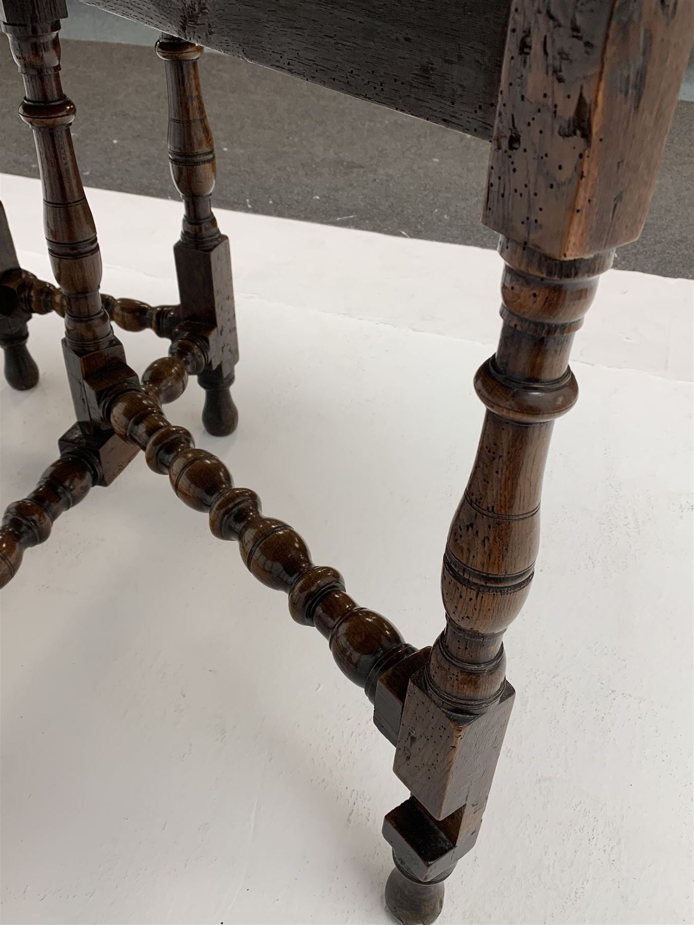 Late 17th century William & Mary oak drop leaf dining table, oval drop leaf top, single drawer to one end, gate action base, turned supports joined by bobbin turned stretchers, 121cm x 135cm, H75cm (open)