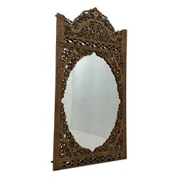 Large North African design carved and painted wall mirror, decorated with floral motifs, pierced foliate scrolls, inset mirrored panels, and colourful painted detailing, enclosing an oval bevelled mirror plate