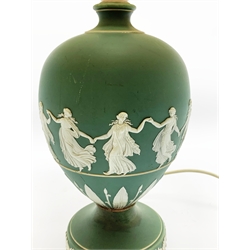 A Wedgwood green Jasperware table lamp, of ovoid form upon a spreading circular foot, decorated with dancing hours, with cream shade, overall H44.5cm. 