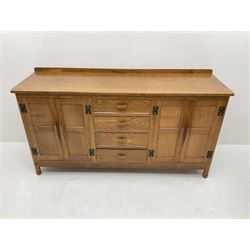'Acornman' oak sideboard, rectangular top with raised back over four drawers and two double cupboards, the cupboards enclosed by panelled doors, panelled sides, on octagonal feet, by Alan Grainger of Brandsby, York