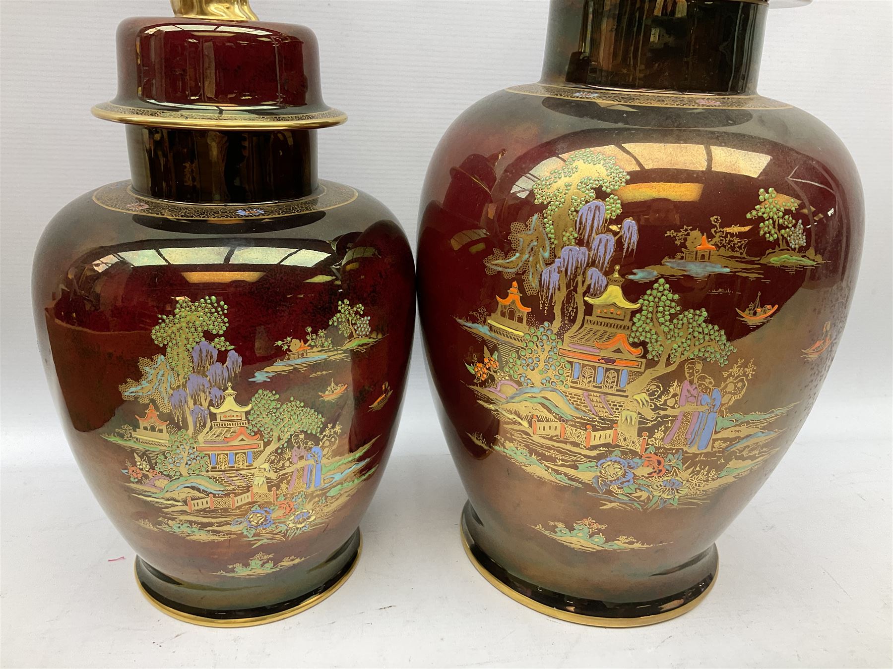 Two Crown Devon Rouge Royale pattern large temple jars with temple dog finial to lid, together with seven other Crown Devon ceramics and two lidded Carlton Ware temple jars in Red Royale, tallest example H47cm (11)