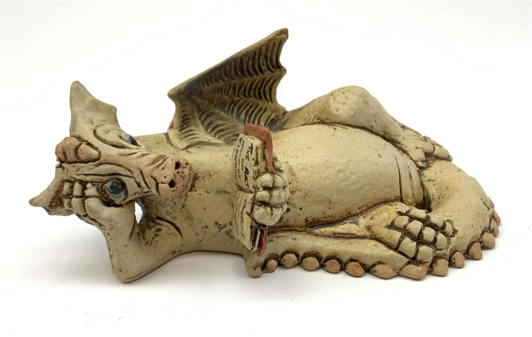 Zell Osbourne (British, Contemporary), Bookworm, a Studio Pottery figure modelled as a recumbent dragon with book, L21cm. 