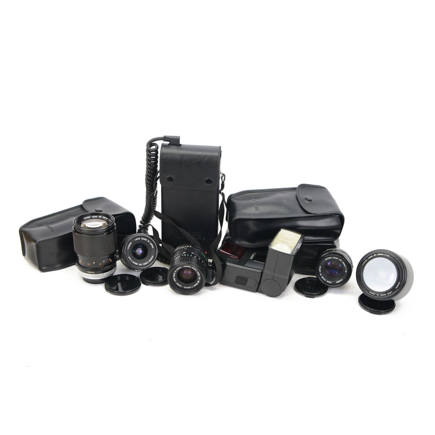 Collection of Canon camera lenses and accessories, including EF 50m 1:1.4 lens, EF 35mm 1:2 lensFD 28mm 1:2.8 lens, FD 50mm 1:1.8 lens, FD 135mm 1:2.5 S.C lens, FD35-70mm 1:3.5-4.5 lens, three Speedlite 550EX flashes, Transistor pack E, lens hoods, battery chargers, etc 