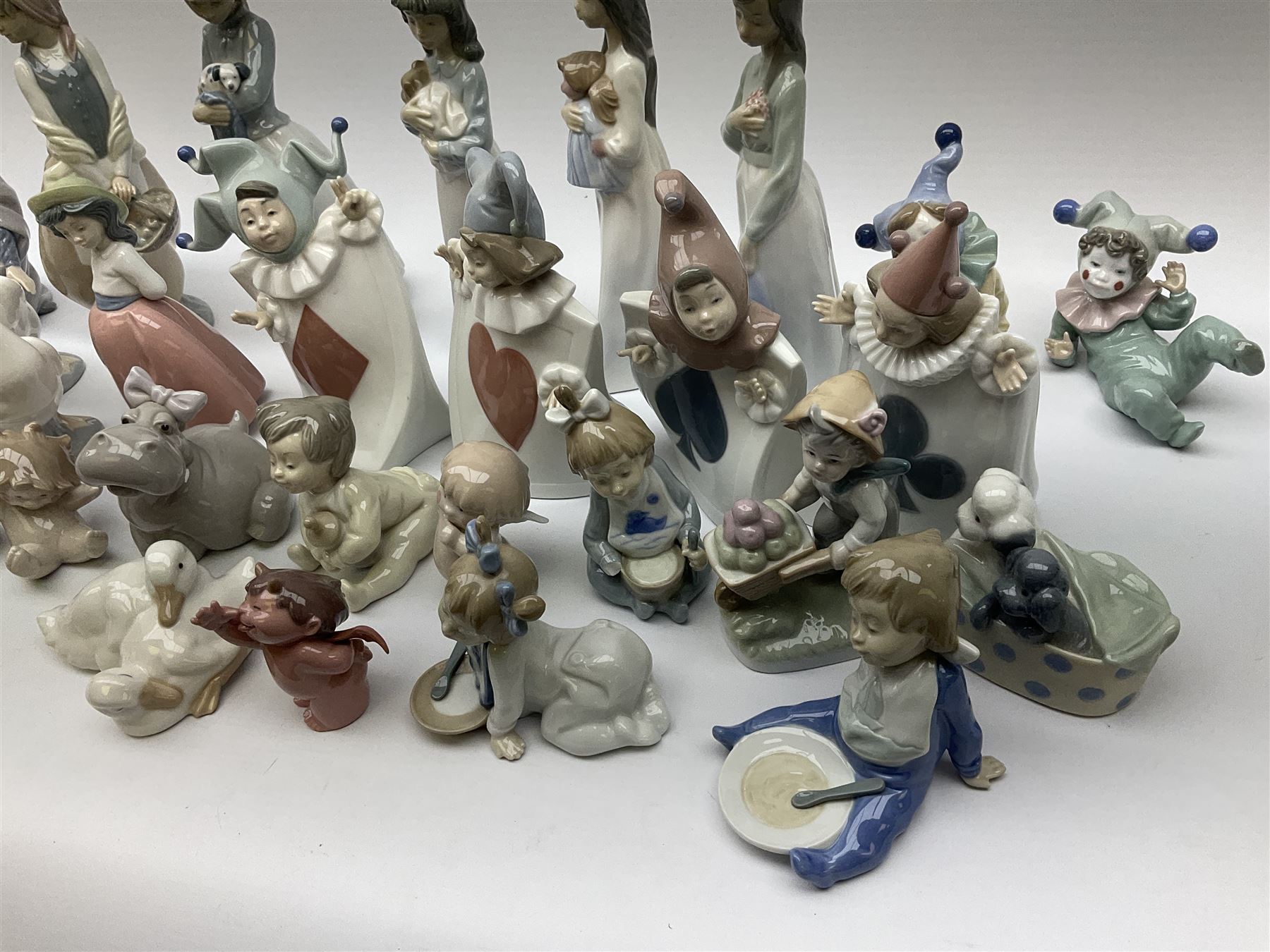 Collection of Nao figures, including four playing card jesters, two clowns, Virgin Mary and baby Jesus , five geese etc. 