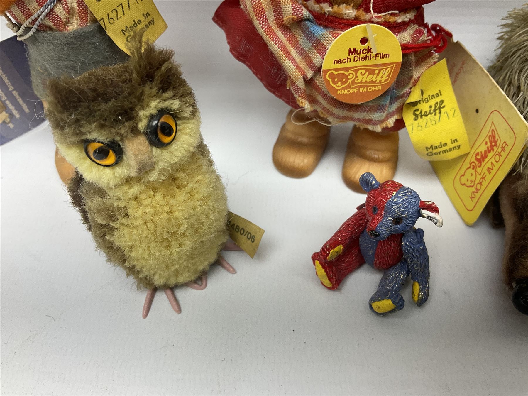 Group of Steiff figures, comprising Mikki and Mukki, circa 1950s no 7628/12 and 7627/12, with original tags, two hedgehogs no 1570/10, and another smaller 1670/03, small owl no 7480/06, and painted metal Steiff harlequin style bear