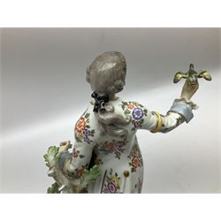 20th century Meissen figure, 'The Good Shepherd', modelled as a gentleman in 18th century dress with bird upon outstretched hand, stood against a tree with recumbent sheep at his feet, upon a scrolling base heightened with gilt, with underglaze blue crossed swords mark beneath, H26cm