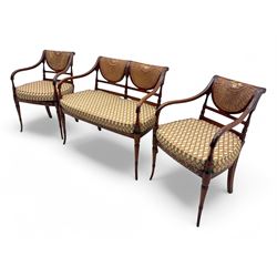 Edwardian Sheraton Revival inlaid mahogany parlour suite, comprising a two-seater settee and two matching armchairs, each with fan-shaped caned back, shaped crest rail with foliate inlay, scrolled open arms, upholstered seat with repeating geometric pattern, on turned and tapered front supports