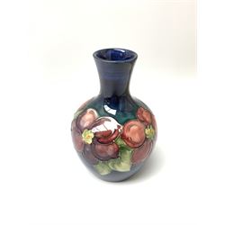 A Moorcroft vase, decorated in the clematis pattern upon a dark blue glazed ground, with paper label beneath detailed Potter to the late Queen Mary, H12.5cm.