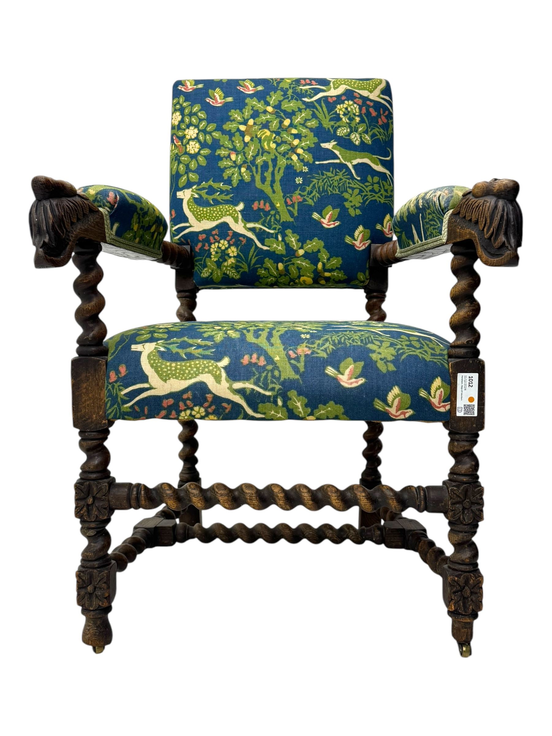 19th century Carolean design oak armchair, upholstered in a vibrant fabric depicting woodland and wildlife scenes, carved lion mask arm terminals, raised on barley twist supports united by H-stretcher