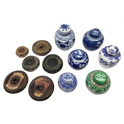 Six Chinese ginger jars, predominantly of blue and white design decorated with blossoming branches, all with lids, housed on various hardwood carved stands, some with character marks beneath