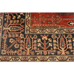 Anatolian crimson ground tribal rug, the field decorated with repeating geometric tree of life motifs with figural designs, the indigo guard band with stylised palmettes