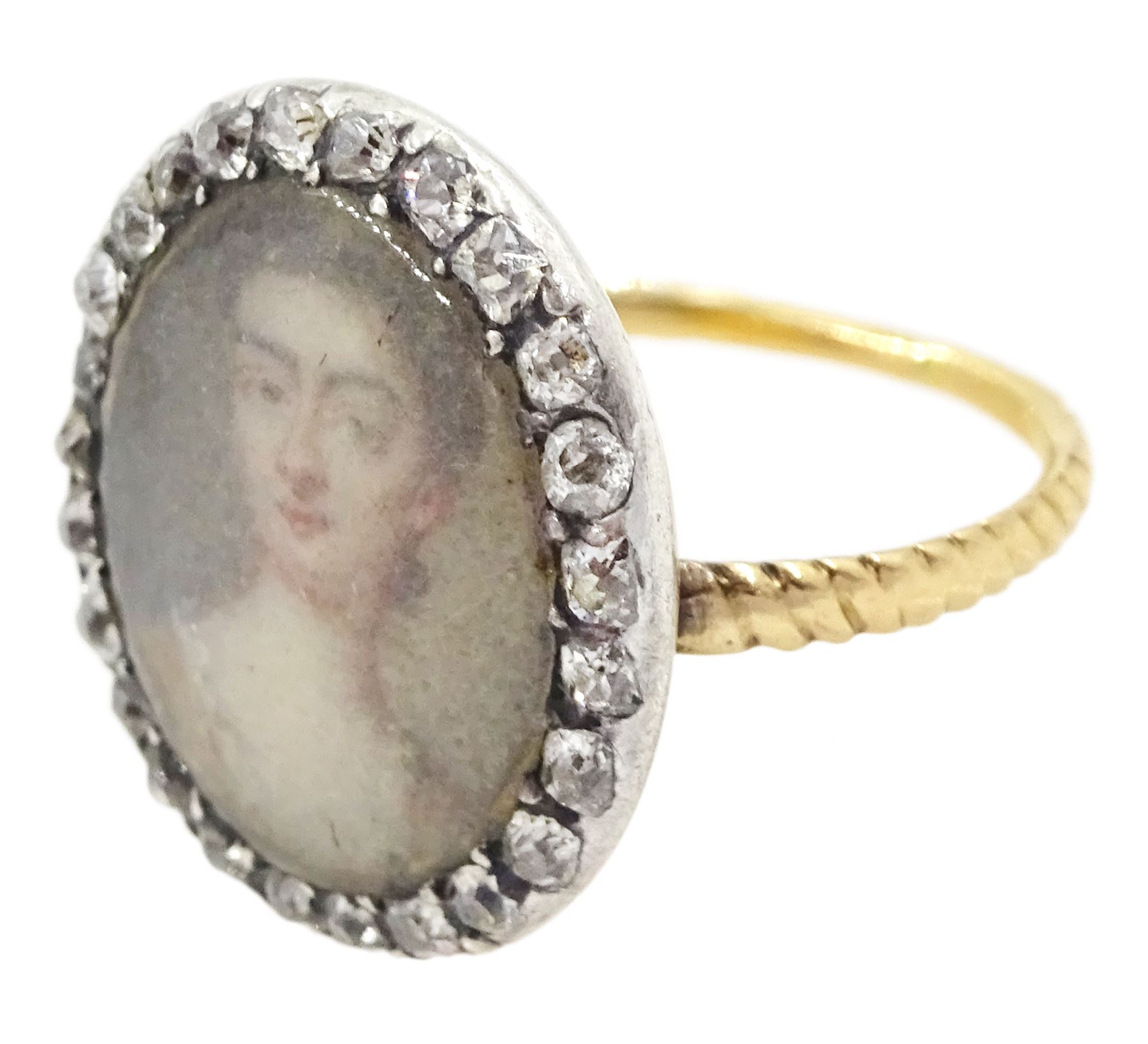 18th/ 19th century gold diamond portrait ring, set with an oval miniature of a woman on ivory, under a glazed panel, with old cut diamond surround and rope twist shank. This lot has been registered for sale under Section 10 of the APHA Ivory Act