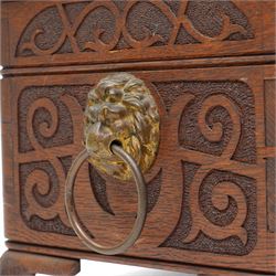 Arts & Crafts Design oak sewing box carved with initials and dated 1907, with sliding top, lion mask ring handles on shaped supports. W36cm