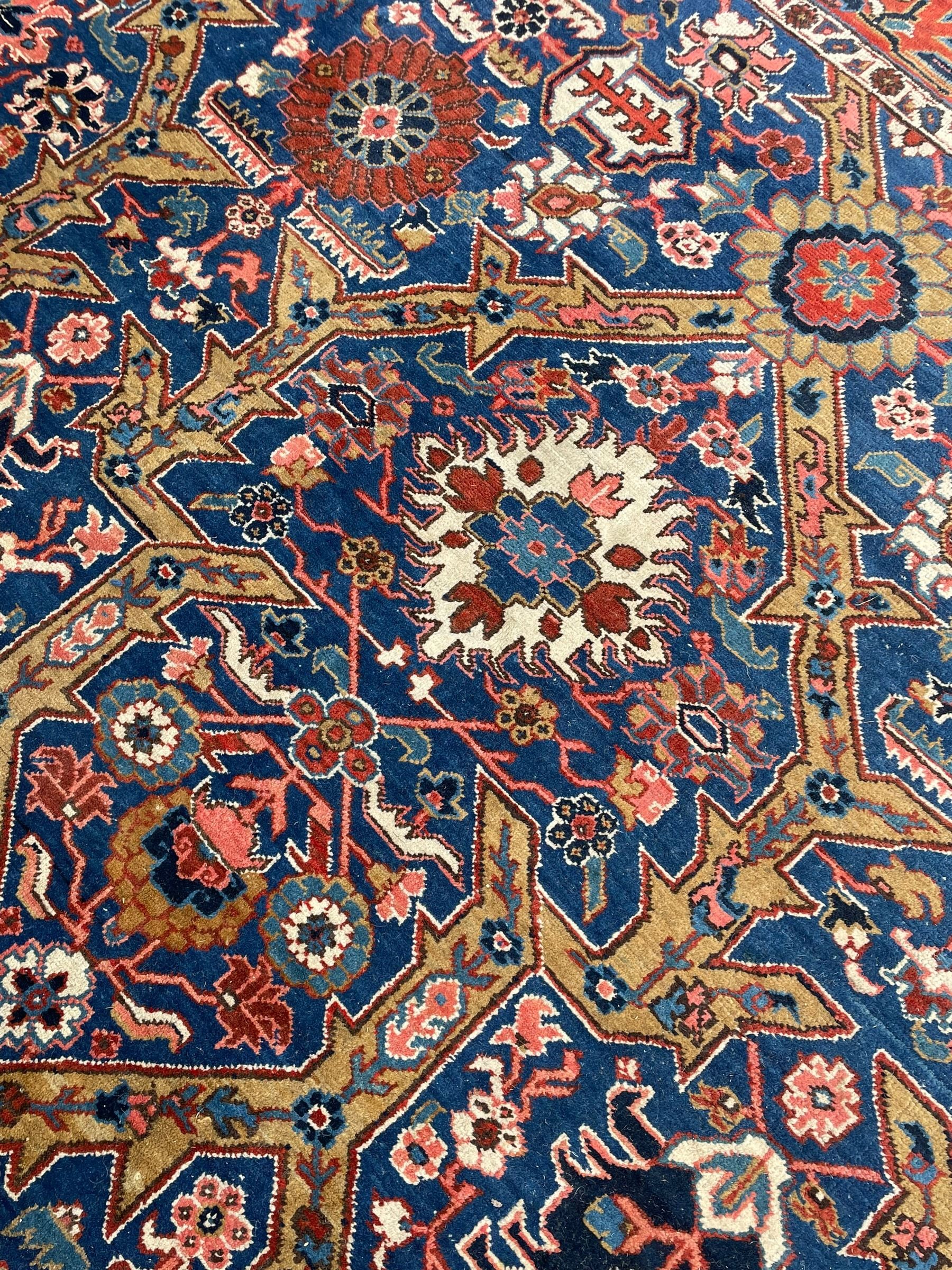 Persian blue ground carpet, the field divided up into panels by trailing bands with flower heads, each panel decorated with palmettes and stylised plant motifs, the border decorated with further palmettes, within floral pattern guard stripes 