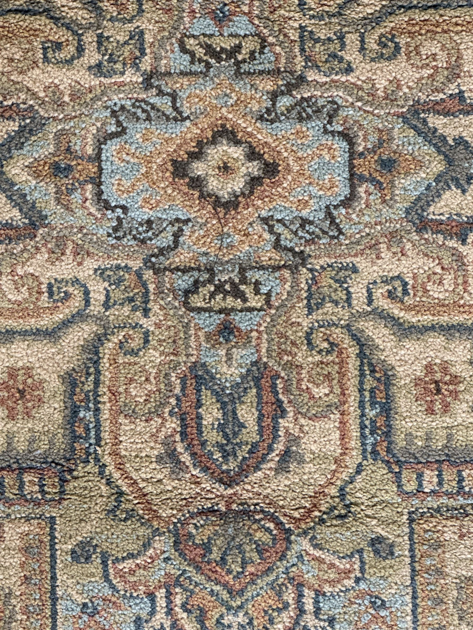 Ziegler-style machine-made rug, beige ground with a multicoloured central medallion and floral motifs, spandrels with scrolling designs, framed by a decorative border with intricate patterns