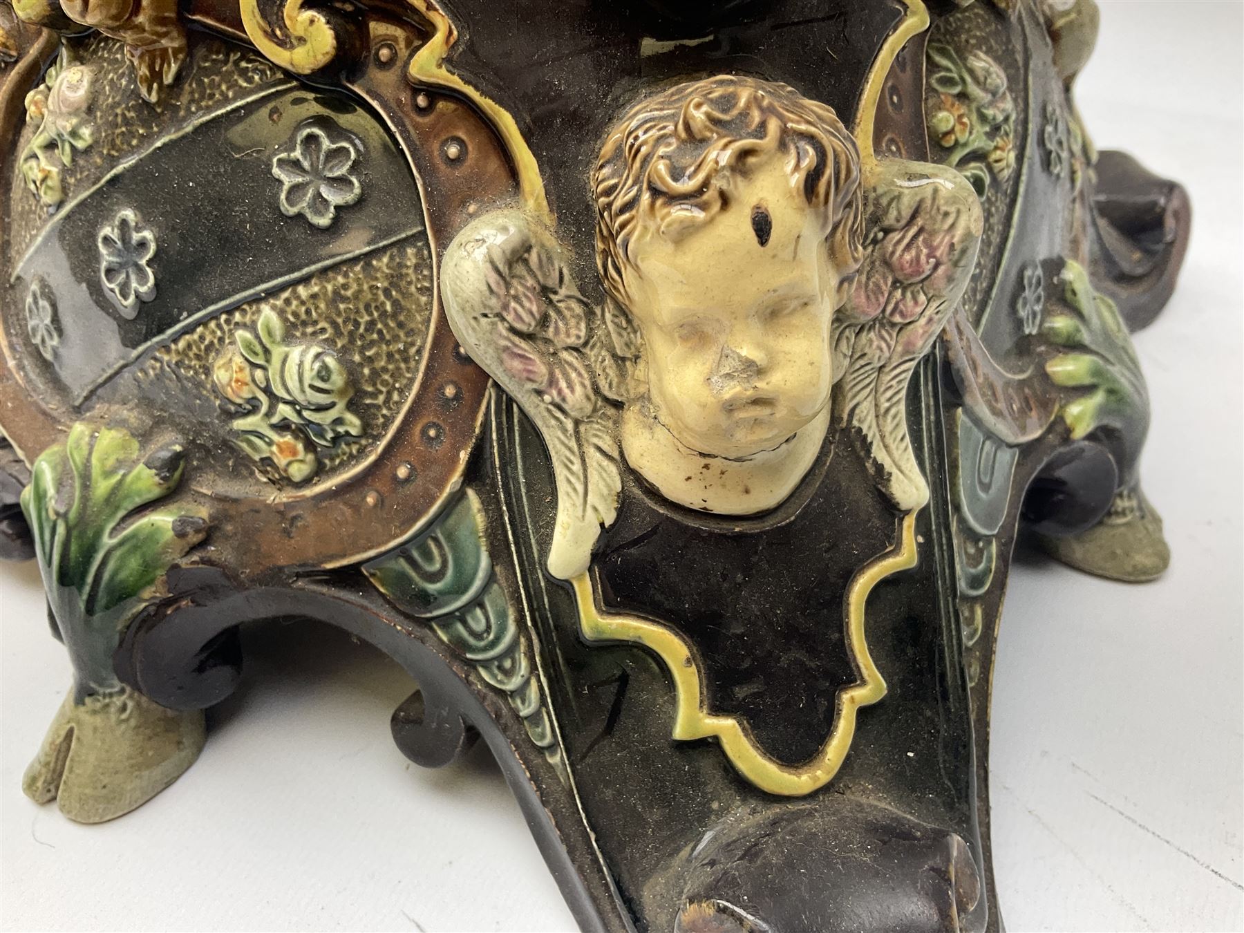 Composite table lamp modelled as a Roman Emperor donning blue robes, upon quatrefoil base modelled with rams heads and winged cherubs, H56cm excl fitting