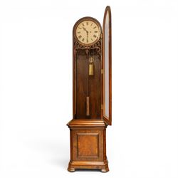 Late 19th century Vienna walnut regulator wall clock, arched glazed case with moulded cornice and figured walnut veneers, circular enamel dial with Roman numerals and pierced hands, carved foliate fretwork beneath the dial, single pendulum movement with brass weights and glazed lower section