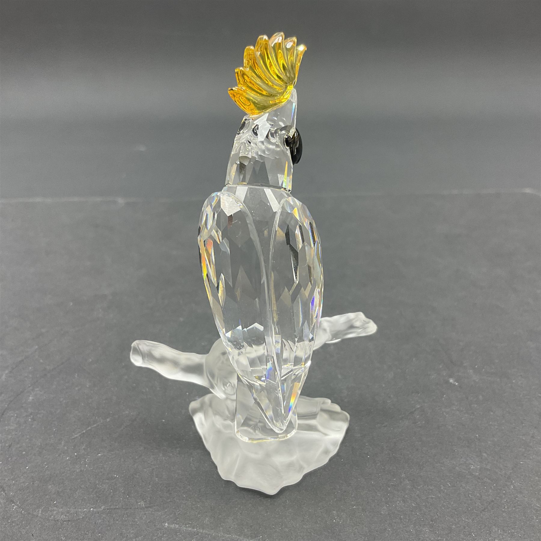 Four Swarovski Crystal bird figures, comprising Cockatoo, pair of Hoopoes on a branch, four Lovebirds on a branch and four Hummingbirds on a branch, largest H10cm