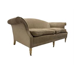 Traditional three seat sofa, curved back over scrolled arms, upholstered in crushed beige fabric with matching loose cushions, on turned front supports with brass and ceramic castors, together with matching footstool