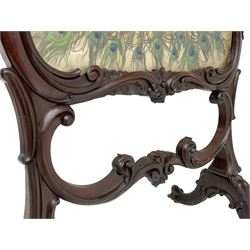 Late 19th century mahogany fire screen, the carved cresting rail with a central cartouche flanked by trailing scrolls surrounding the glazed screen enclosing peacock feathers, the middle rail with further scrollwork and scalloped patterns, raised on shaped end supports with splayed and scrolled cabriole feet on castors