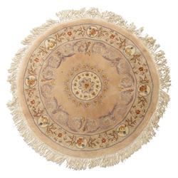 Late 20th-century circular peach-toned rug, with central floral rosette medallion surround...