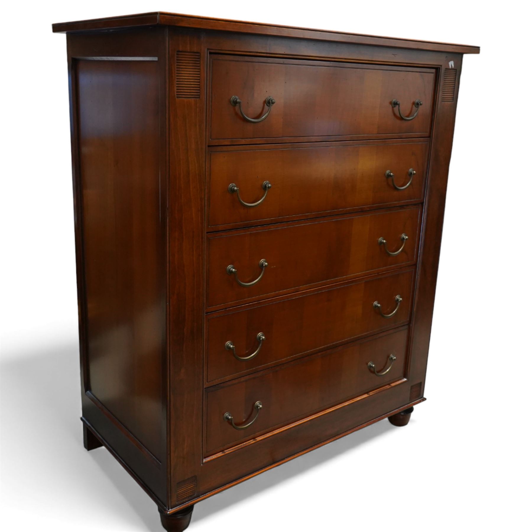 French cherry wood chest of drawers, rectangular moulded top above five long drawers with brass swing handles, flanked by reeded corner panels, raised on turned bun feet