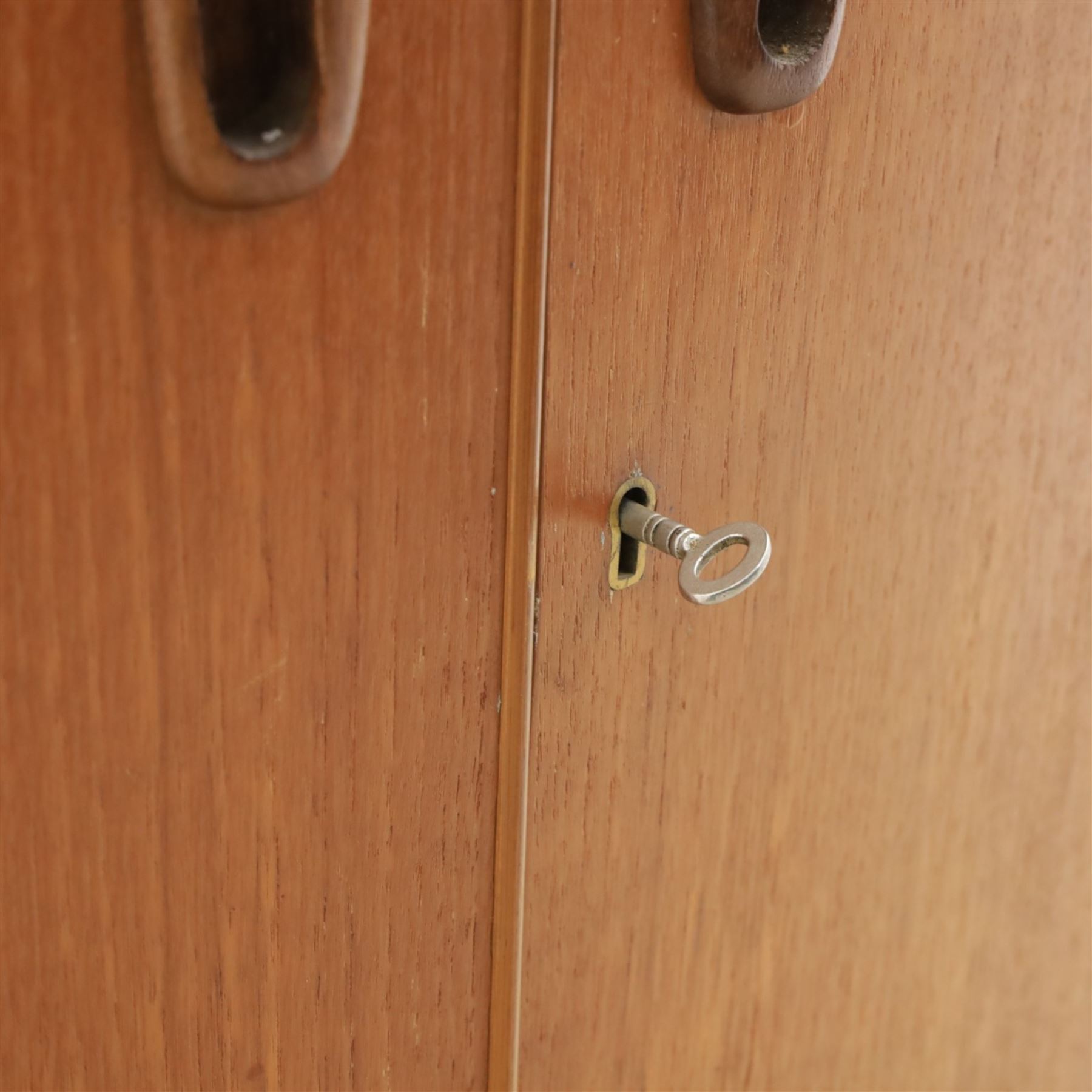 Turnbridge of London - Mid 20th century teak cocktail cabinet, with fold out top extending to 160cm, with twin doors revealing a shelved interior, the back with sliding glazed doors, raised on a recessed plinth base with castors